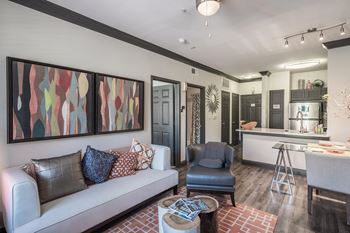 a living room with a couch and a chair and a kitchen